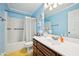 Bathroom featuring blue walls, vanity with sink, and tub with shower, creating a fresh and functional space at 330 Pitts Chapel Rd, Newborn, GA 30056
