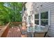 Backyard deck featuring a table and chairs with a view of a lush, wooded area and door to enter home at 3945 Lorien Way, Kennesaw, GA 30152