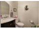 Half bathroom with dark vanity, marble countertop, mirror, and floral decoration at 3945 Lorien Way, Kennesaw, GA 30152