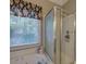 Bright bathroom featuring a jacuzzi tub under a window and a glass-door shower at 3945 Lorien Way, Kennesaw, GA 30152