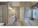 Neutral-colored bathroom featuring double sinks, a jacuzzi tub, and a glass-door shower at 3945 Lorien Way, Kennesaw, GA 30152