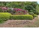 Stone entrance sign for Autumn Woods community surrounded by colorful flowers and shrubbery at 3945 Lorien Way, Kennesaw, GA 30152