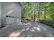A two-car garage attached to a light-colored two-story home, surrounded by lush trees at 3945 Lorien Way, Kennesaw, GA 30152