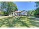Spacious backyard with a view of the house, sunroom, and patio area, surrounded by trees at 4735 Rabbit Farm Rd, Loganville, GA 30052