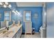 Bright blue bathroom featuring a double sink vanity, toilet and glass door shower at 4735 Rabbit Farm Rd, Loganville, GA 30052