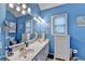 Bright blue bathroom featuring a large double vanity, toilet and lighting at 4735 Rabbit Farm Rd, Loganville, GA 30052