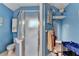 Shower in a bright blue bathroom including a toilet, shelving and vanity at 4735 Rabbit Farm Rd, Loganville, GA 30052