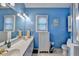 Bright blue bathroom featuring a toilet, vanity, lighting and nautical décor at 4735 Rabbit Farm Rd, Loganville, GA 30052