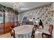 Dining area showcases floral wallpaper, hardwood floors, a china cabinet, and an archway at 4735 Rabbit Farm Rd, Loganville, GA 30052
