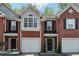 Charming brick townhomes featuring attached garages and manicured front entrances at 215 Morris Ln, Woodstock, GA 30188