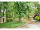 A landscaped backyard with mature trees and a shed offers a serene outdoor space for relaxation and recreation at 4618 Barkley Nw Dr, Acworth, GA 30101