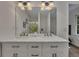 Bathroom featuring double sinks, granite countertops, white cabinets, large mirrors, and modern lighting at 4618 Barkley Nw Dr, Acworth, GA 30101