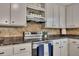 Close-up of a kitchen with a stainless steel stove, tiled backsplash, and modern cabinets at 4618 Barkley Nw Dr, Acworth, GA 30101