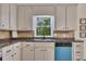 Bright kitchen showcasing the sink, tile backsplash, and a modern blue dishwasher at 4618 Barkley Nw Dr, Acworth, GA 30101