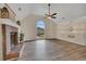 Open living room featuring a brick fireplace, wood floors, vaulted ceiling, and large arched window at 4618 Barkley Nw Dr, Acworth, GA 30101