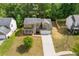 Aerial view of a well-maintained house, with a nicely manicured lawn, a driveway, and charming front porch at 1450 Steam Engine Way, Conyers, GA 30013