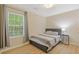 Cozy bedroom with light wood floors, large window and a comfortable bed with stylish side table at 1450 Steam Engine Way, Conyers, GA 30013