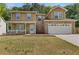 Two-story home featuring stone accents, light brown siding, green shutters, a porch, and two-car garage at 1450 Steam Engine Way, Conyers, GA 30013