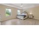 Main bedroom with wood floors, tray ceiling, ceiling fan, and large windows at 1450 Steam Engine Way, Conyers, GA 30013