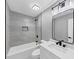Updated bathroom with modern vanity, bathtub, and gray tile at 5854 Cobalt Dr, Powder Springs, GA 30127