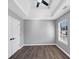This airy bedroom features a tray ceiling, ceiling fan, and warm, wood-look flooring at 5854 Cobalt Dr, Powder Springs, GA 30127