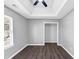 A well-lit bedroom with dark hardwood floors, light grey walls and tray ceiling at 5854 Cobalt Dr, Powder Springs, GA 30127