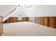 Spacious attic featuring natural light from a window, wood paneled walls, and plush carpeting at 936 Bramble Oak Ct, Powder Springs, GA 30127