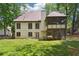 View of the backyard with a well-maintained lawn and a screened-in porch, perfect for enjoying the outdoors at 936 Bramble Oak Ct, Powder Springs, GA 30127