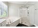 Corner soaking tub and separate glass enclosed shower in updated bathroom at 936 Bramble Oak Ct, Powder Springs, GA 30127