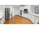 Well-equipped kitchen with stainless steel appliances, white cabinetry, and hardwood floors at 936 Bramble Oak Ct, Powder Springs, GA 30127