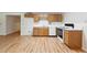 Basement kitchenette area with wood cabinets, white appliances, and laminate flooring at 936 Bramble Oak Ct, Powder Springs, GA 30127