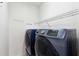 Convenient laundry room with modern washer and dryer units, plus wire rack shelving at 936 Bramble Oak Ct, Powder Springs, GA 30127