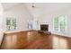 Bright living room features vaulted ceiling, fireplace, wood floors, and large windows at 936 Bramble Oak Ct, Powder Springs, GA 30127