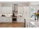 Stylish kitchen with white cabinets, stainless steel appliances, quartz countertops and hardwood floors at 123 Cricket Ln, Alpharetta, GA 30009
