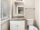 Bathroom featuring a white vanity with granite counter, framed mirror and natural light at 474 Waterford Nw Rd, Atlanta, GA 30318