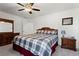 Comfortable bedroom with ceiling fan, a plaid comforter, and bedside tables at 5520 Allegre Pl, Cumming, GA 30028