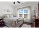 Bright bedroom features a floral comforter, a large window and dark hardwood floors at 5520 Allegre Pl, Cumming, GA 30028