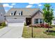 Charming brick and siding home with a well-manicured lawn and an attached two-car garage at 5520 Allegre Pl, Cumming, GA 30028
