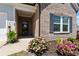 Charming front porch with brick accents and colorful flowers, creating a welcoming entrance at 5520 Allegre Pl, Cumming, GA 30028