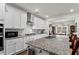 Modern kitchen features granite countertops, stainless appliances, and a large island with seating at 5520 Allegre Pl, Cumming, GA 30028