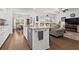 Modern kitchen and living room featuring an open concept with granite countertops and stainless appliances at 5520 Allegre Pl, Cumming, GA 30028