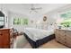 Main bedroom with a large window, ceiling fan, dressers, and a plush bed at 2620 Margaret Mitchell Dr, Atlanta, GA 30327