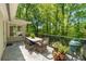 Outdoor patio with stone floor, dining table, chairs, grill, and wooded view at 2620 Margaret Mitchell Dr, Atlanta, GA 30327