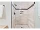 Walk-in shower with glass door, neutral tile, and a decorative accent stripe at 2620 Margaret Mitchell Dr, Atlanta, GA 30327