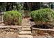 Stone steps leading to a secluded garden area with manicured bushes and retaining walls, adding charm to the landscape at 2620 Margaret Mitchell Dr, Atlanta, GA 30327