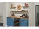 Bar area with open shelving and wine storage, as well as room for a coffee maker and glasses with a refrigerator at 3862 Firewood Ln # 110, Suwanee, GA 30024