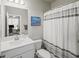 Bathroom with white cabinetry, shower and tub combo, and a view to the outside at 3862 Firewood Ln # 110, Suwanee, GA 30024