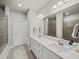 Bright bathroom featuring a double sink vanity with white cabinets and a large mirror at 3862 Firewood Ln # 110, Suwanee, GA 30024
