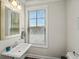 Bathroom featuring a pedestal sink, neutral color palette, and view to the outside at 3862 Firewood Ln # 110, Suwanee, GA 30024