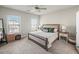 Bedroom featuring a large bed, two windows, and neutral decor at 3862 Firewood Ln # 110, Suwanee, GA 30024